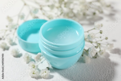 Lip balm and gypsophila on white background  closeup