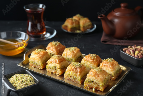 Delicious fresh baklava with chopped nuts served on dark textured table. Eastern sweets