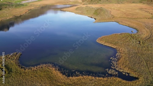 Drone capture of the small lake in the grass land with undefined boundaries situated in the valley  photo