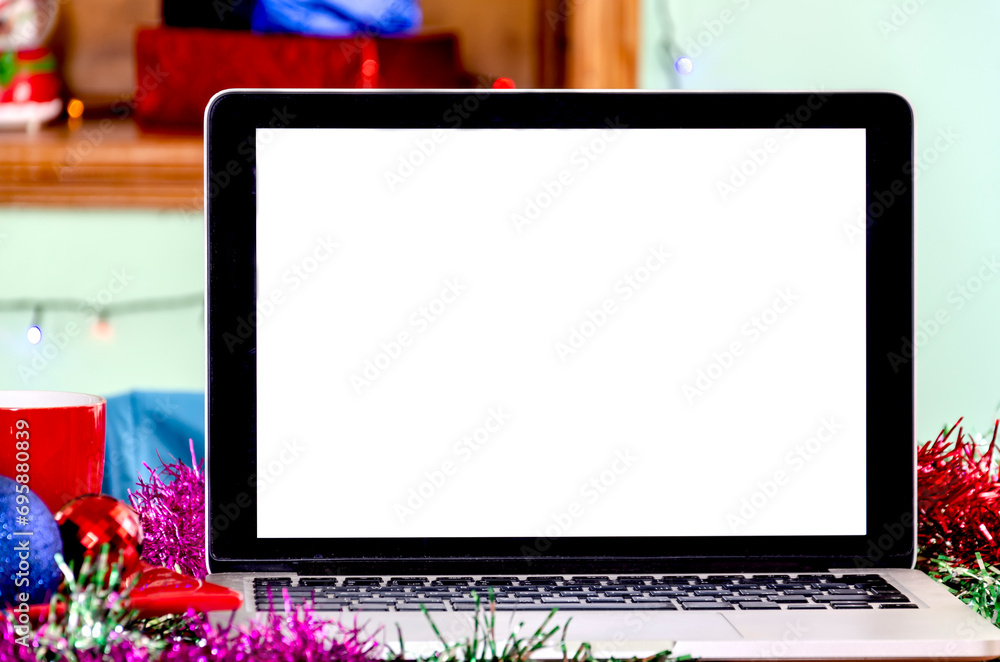 Close-up photo of white screen of laptop standing on festive table at wonderful Christmas Day. Empty space and place for text concept Close-up photo of white screen of laptop standing on festive table at wonderful Christmas Day. Empty space and place for text concept