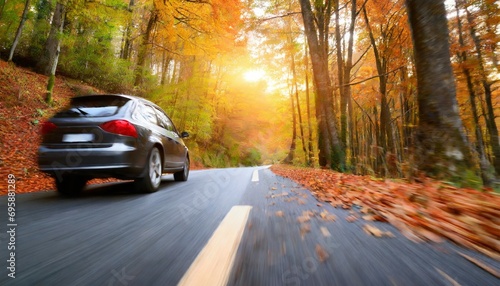 car on the road in the autumn forest speed motion blur effect