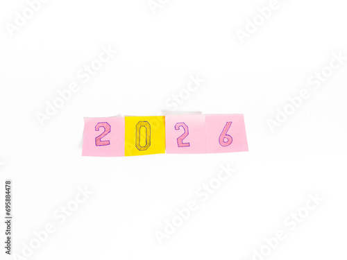 handwritten on a pink and yellow note paper written 2026 separately, on a white background