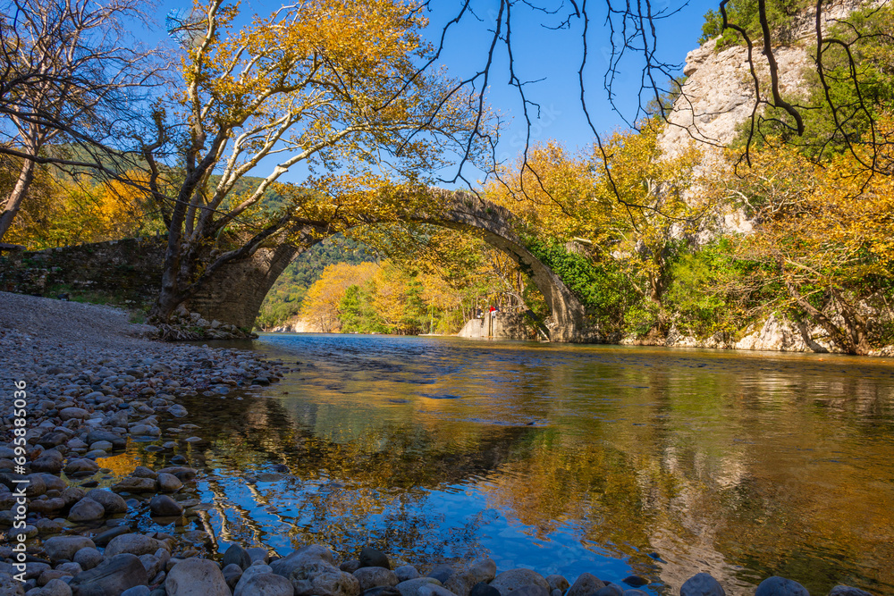 The fantastic Klidonia Ottoman bridge, adobe the peaceful Voidomatis river, in a beautiful morning light and reflections, Zagori, Greece