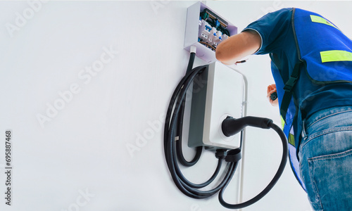 Certified male Electrician Installing Home EV Charger photo