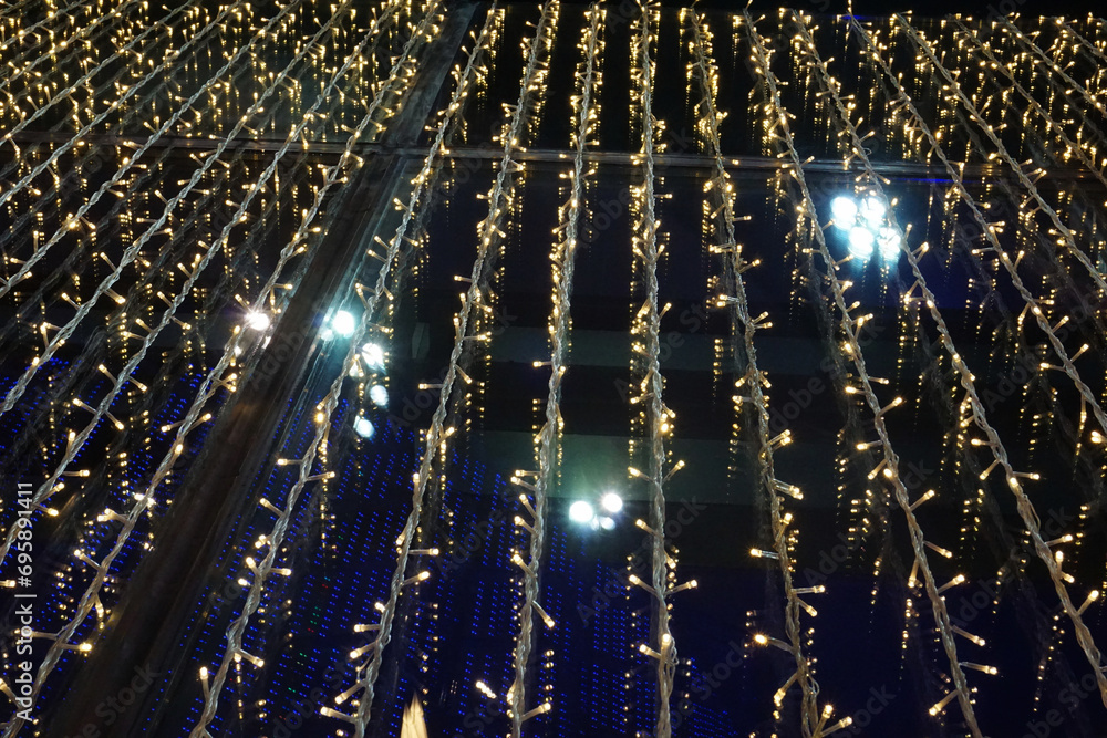 Naklejka premium Bokeh. Close-up Christmas tree. An abstract background of lights in the city at night.