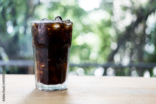 Close up glass of iced black coffee on wooden table