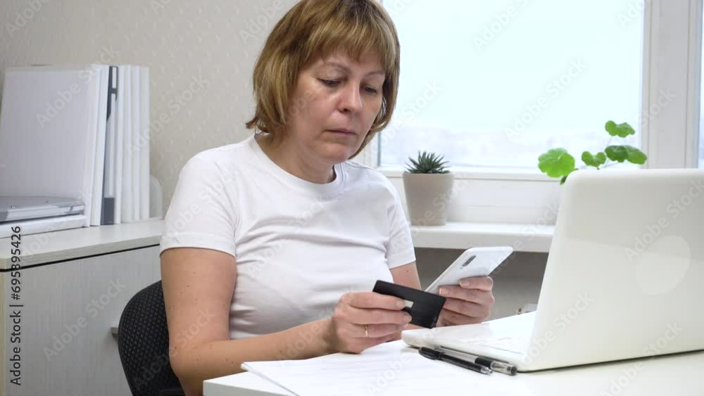 A woman enters her bank card details to pay online. Close-up. Suitable for content about online trading, online sales, electronic payments, online shopping. A woman enters her bank card details to pay online. Close-up. Suitable for content about online trading, online sales, electronic payments, online shopping.