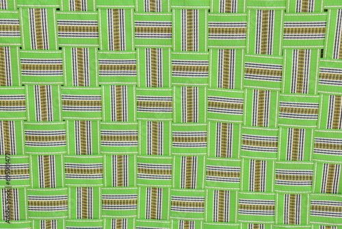 Green colored nylon Foldable Khatia or chaarpai standing with support of white wall , closeup of criss cross pattern photo