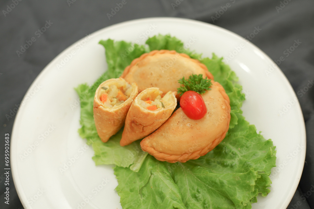Fried Pastel or Pastel Goreng are a Kind of Pastry Popular in Indonesia, Made by placing Carrot an Potato on top of the dough, Then Folded and Tightly Closed. Selective focus.
Fried Pastel or Pastel Goreng are a Kind of Pastry Popular in Indonesia, Made by placing Carrot an Potato on top of the dough, Then Folded and Tightly Closed. Selective focus.