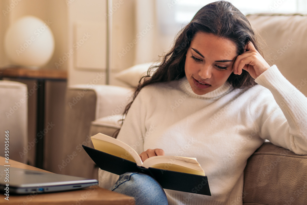 Relaxing at Home: Young Woman Reading a Book Relaxing at Home: Young Woman Reading a Book