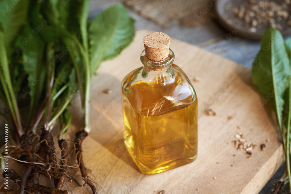 A bottle of dandelion root tincture with fresh plant A bottle of dandelion root tincture with fresh plant