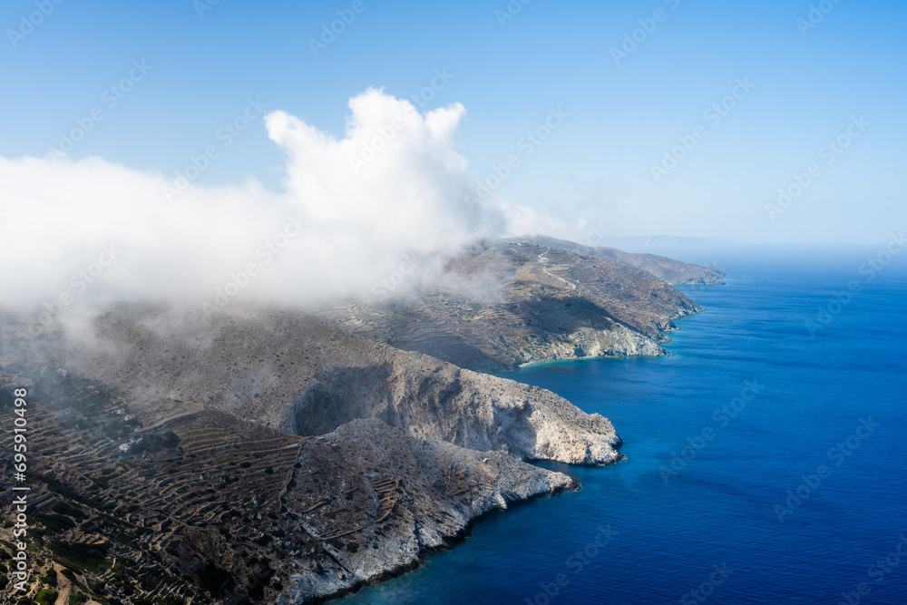Landscape of Folegandros Island with a cloud and blue sky. Aegean Sea. Cyclades of Greece. Landscape of Folegandros Island with a cloud and blue sky. Aegean Sea. Cyclades of Greece.