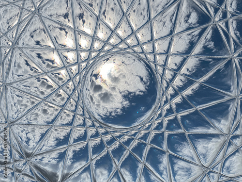 Φωτογραφία upward view of the sky with sun shining through clouds seen through a beveled or