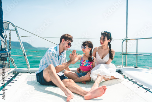 Happy carefree family travel adventures for young parents with daughter relaxing on luxury yacht at sunset, Sailing on catamaran having fun and good