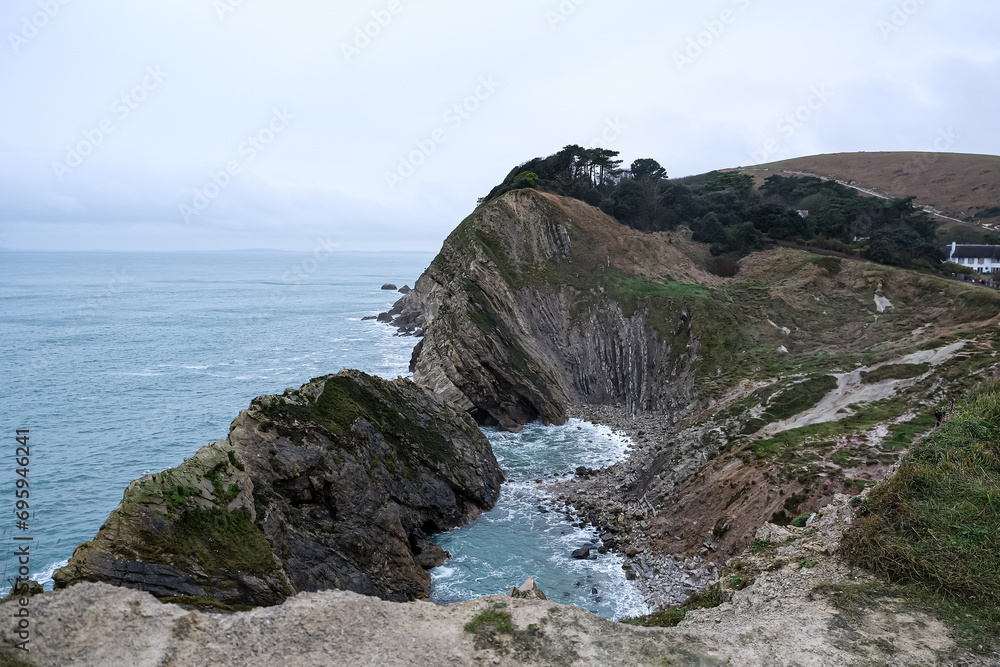 Lulworth Cove cliffs view on a way to Durdle Door. The Jurassic Coast is World Heritage Site on the English Channel coast of southern England. Dorset, UK. Jurassic coast view in Dorset, UK. Stair Hole Lulworth Cove cliffs view on a way to Durdle Door. The Jurassic Coast is World Heritage Site on the English Channel coast of southern England. Dorset, UK. Jurassic coast view in Dorset, UK. Stair Hole