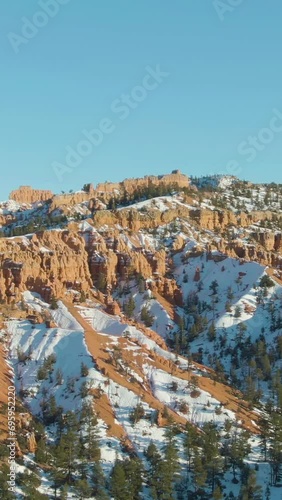 Red Canyon Hoodoos on Winter Sunny Evening. Dixie National Forest. Blue Sky. Utah, USA. Aerial View. Drone is Orbiting. Vertical Video photo