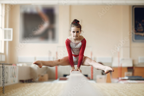 Prepare young child athlete gymnast on balance beam photo