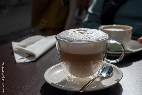 Fototapeta Naklejka Na Ścianę i Meble -  Drinking tasty fresh brewed Italian caffe latte coffee with whipped milk in outdoor cafe