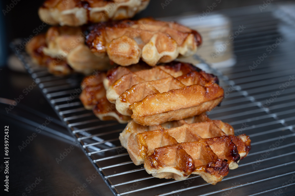 Eating of fresh baked hot Belgian sugar waffles, street food in Bruges