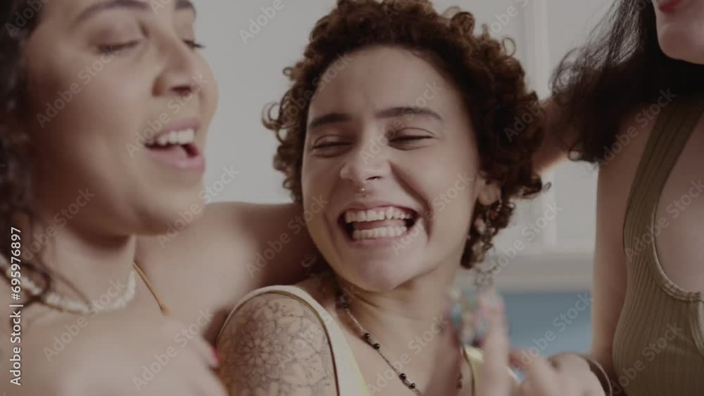 Amigas felizes,comendo brigadeiro na cozinha e se abracando. Cinematico 4k.