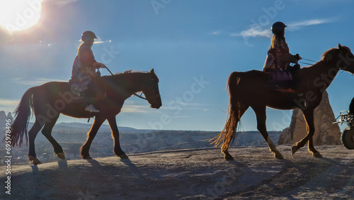 Silhouettes of two horses gracefully galloping through the mystique of Red Valley.