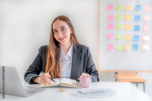 Business woman hand putting coin into piggy banks with gold coins pile growth graph, Saving money for future investment plan and retirement fund concept