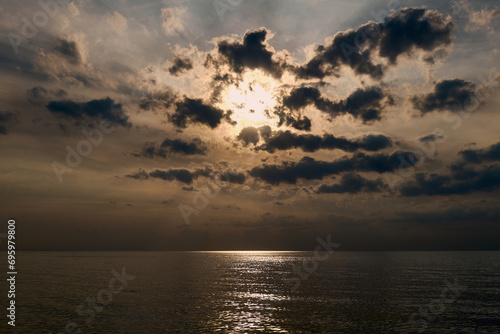 Fototapeta Naklejka Na Ścianę i Meble -  Dramatic sunset on the seaside, sun behind dark clouds, calm Baltic Sea