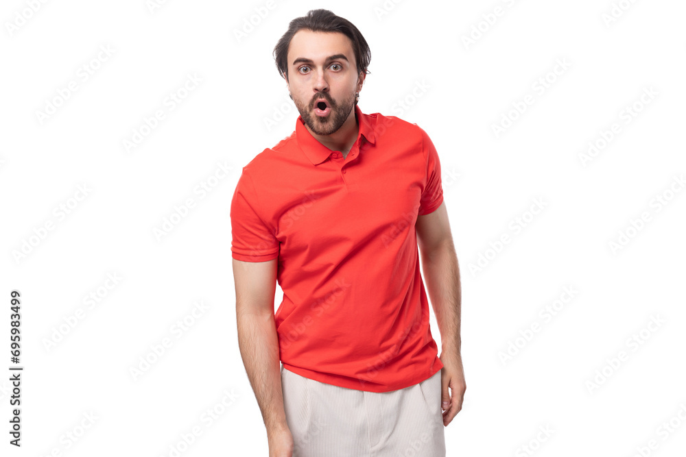 young handsome brunette man with a beard is dressed in a standard red t-shirt on a white background with copy space young handsome brunette man with a beard is dressed in a standard red t-shirt on a white background with copy space