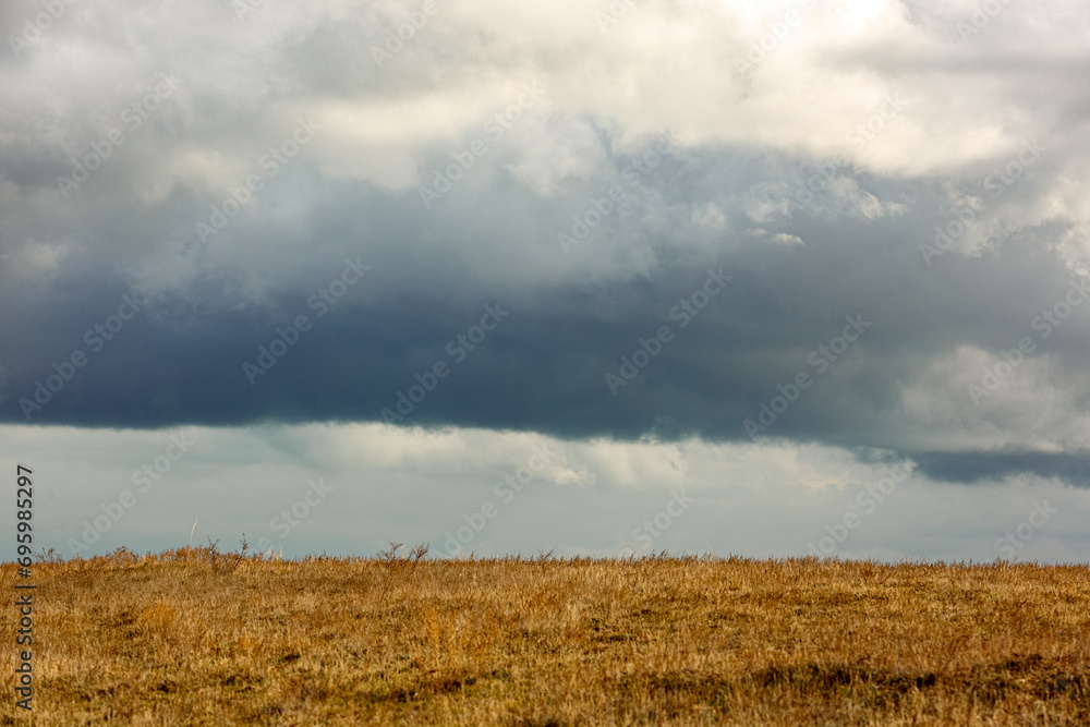 Fototapeta premium Clouds over the field
