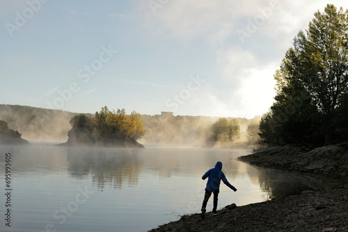 silhouette in front of a misty lake photo