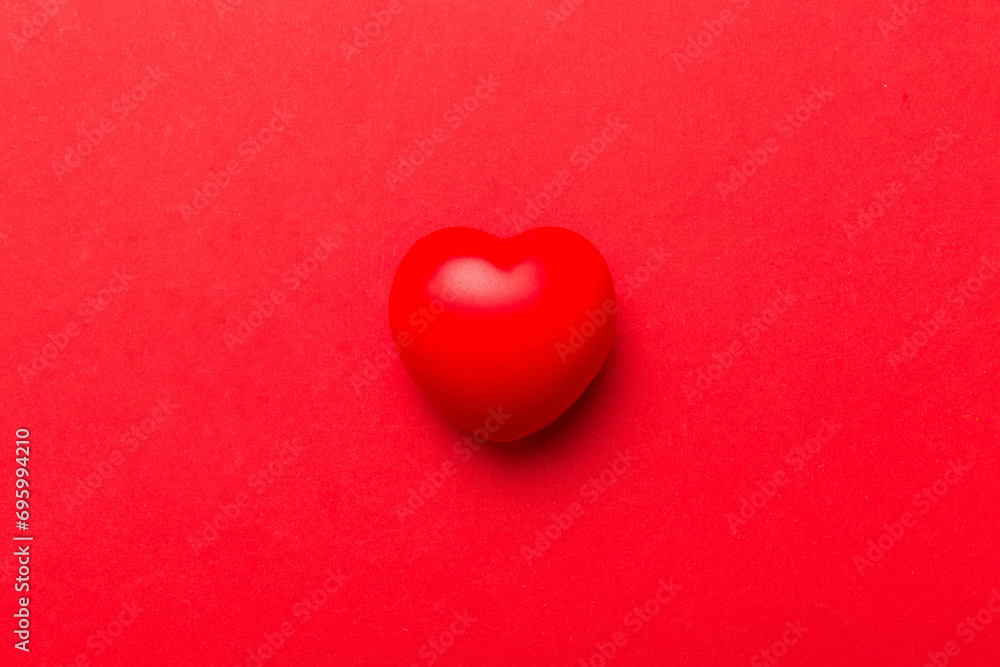 Obraz premium red heart shape on colored background. minimal concept top view with copy space