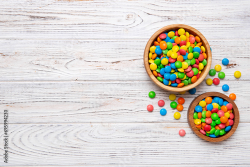 different colored round candy in bowl and jars. Top view of large variety sweets and candies with copy space