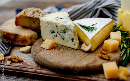 Cheese Plate With Nuts And Honey Is Laid Out On A Wooden Board photo