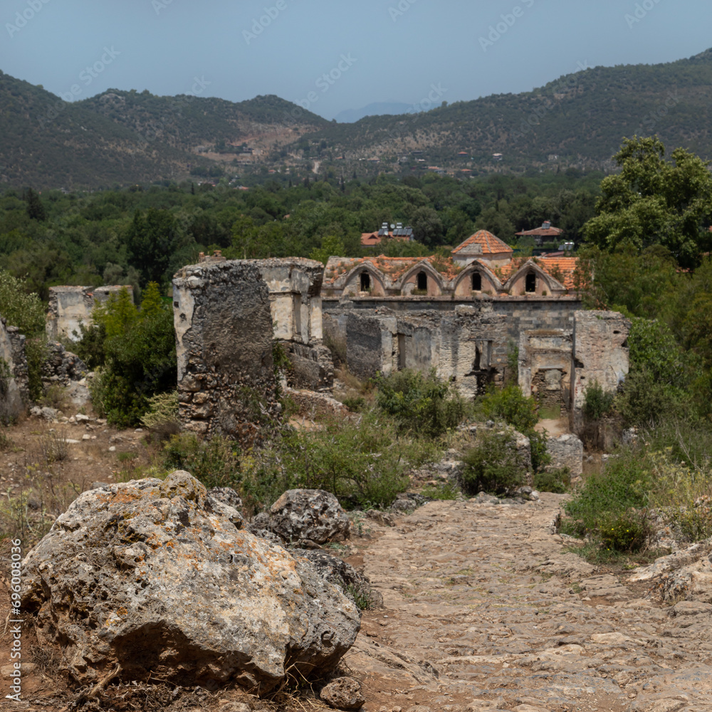 Abandoned Village of Kayakoy: many deserted stone houses, dead city looks like ancient ruins. Yukari Kilise is an old Greek damaged church. Abandoned Village of Kayakoy: many deserted stone houses, dead city looks like ancient ruins. Yukari Kilise is an old Greek damaged church.