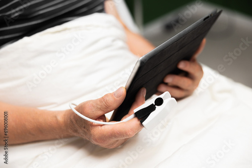 On the path to healing, the senior patient in the hospital bed reads personal development articles on his tablet, fostering a mindset of growth and resilience.