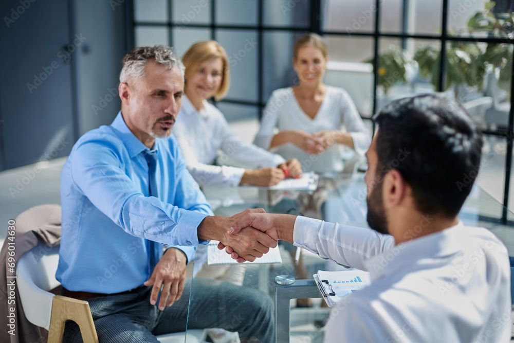 Obraz premium handshake of the boss and the employee sitting at the Desk in the office