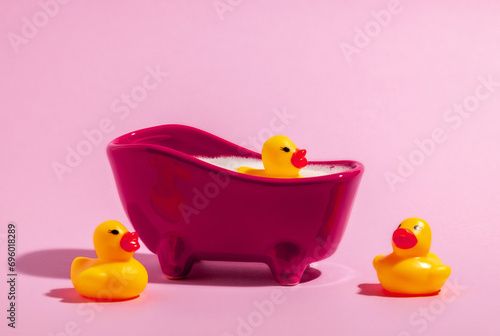Lttle bath with rubber ducks on pink background.