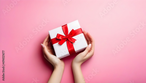 Close up on female hands holding a gift for Valentine's Day, birthday, Mother's Day. Symbol of love. Valentines day background with gift boxes