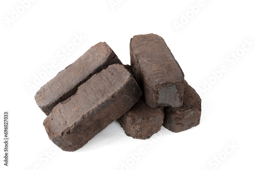 peat fuel briquettes, an alternative type of fuel for heating. Close-up, on isolated white © OLEKSANDR