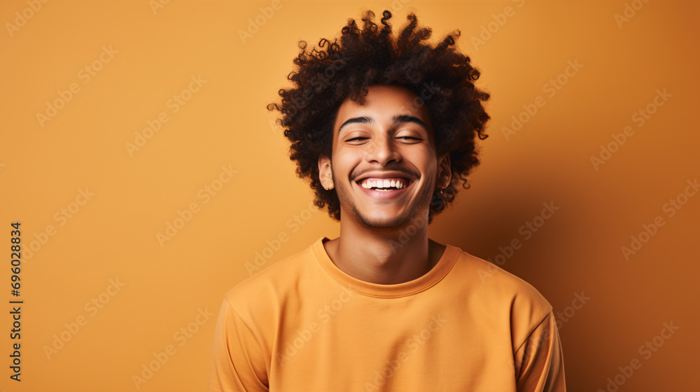 A beaming African-American Gen-Zer, sporting cool, curly hair and flawless white teeth, winks whilst isolated on a beige backdrop.