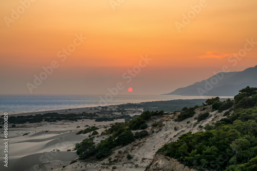 Fototapeta Naklejka Na Ścianę i Meble -  Sunset in reddish over Patara (Pttra) beach, sand dunes and sea. Kalkan, Antalya - Turkey