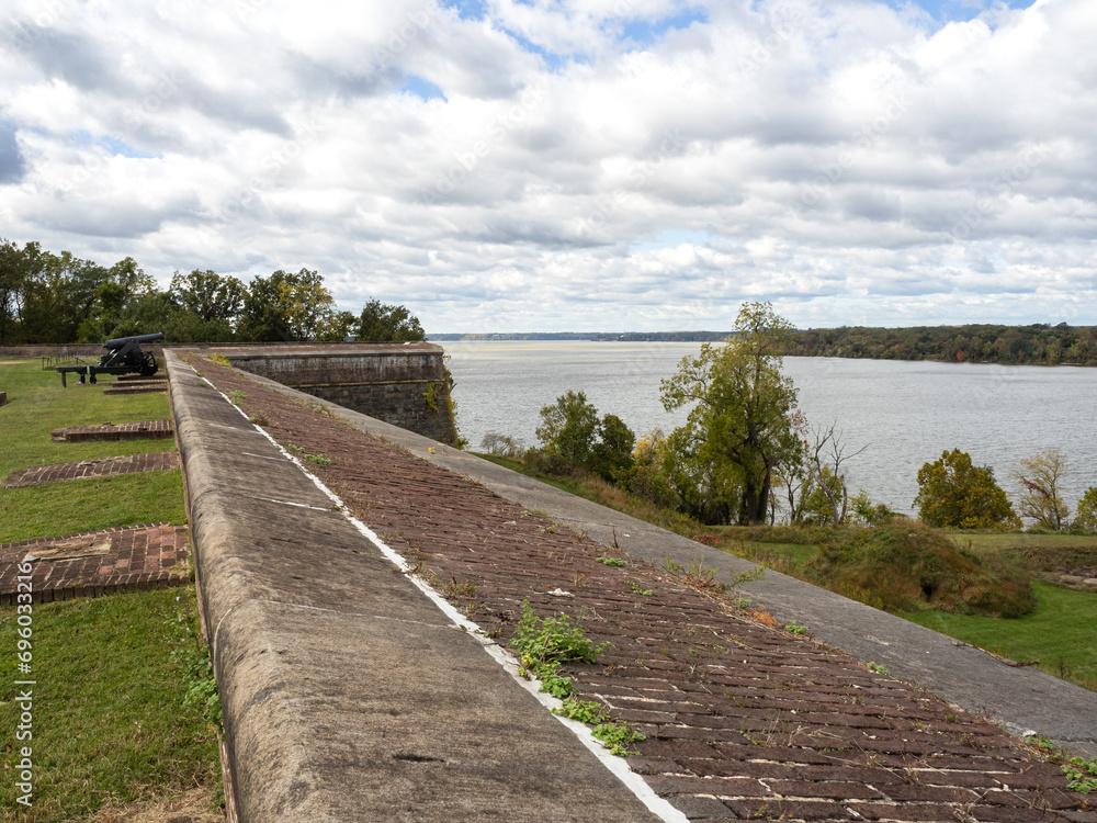 One of the massive walls of Fort Washington, Virginia, with the Potomac River and a cannon in the background.