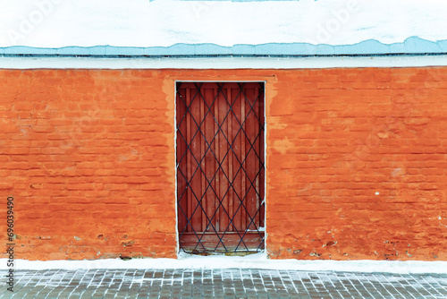 Door and metal grille in red brick wall