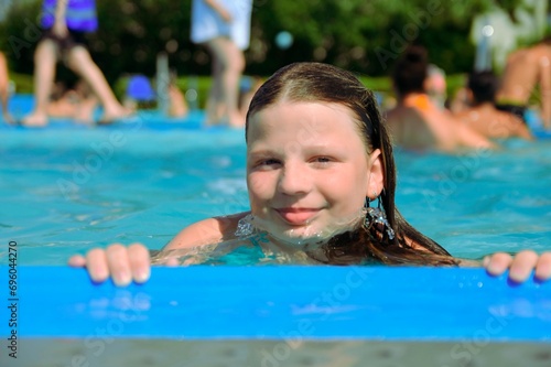 A little girl at the edge of the pool. Small child on the edge of the pool. Vibes of the 80s. Small girl in the pool. The concept of summer, water fun and summer fun.