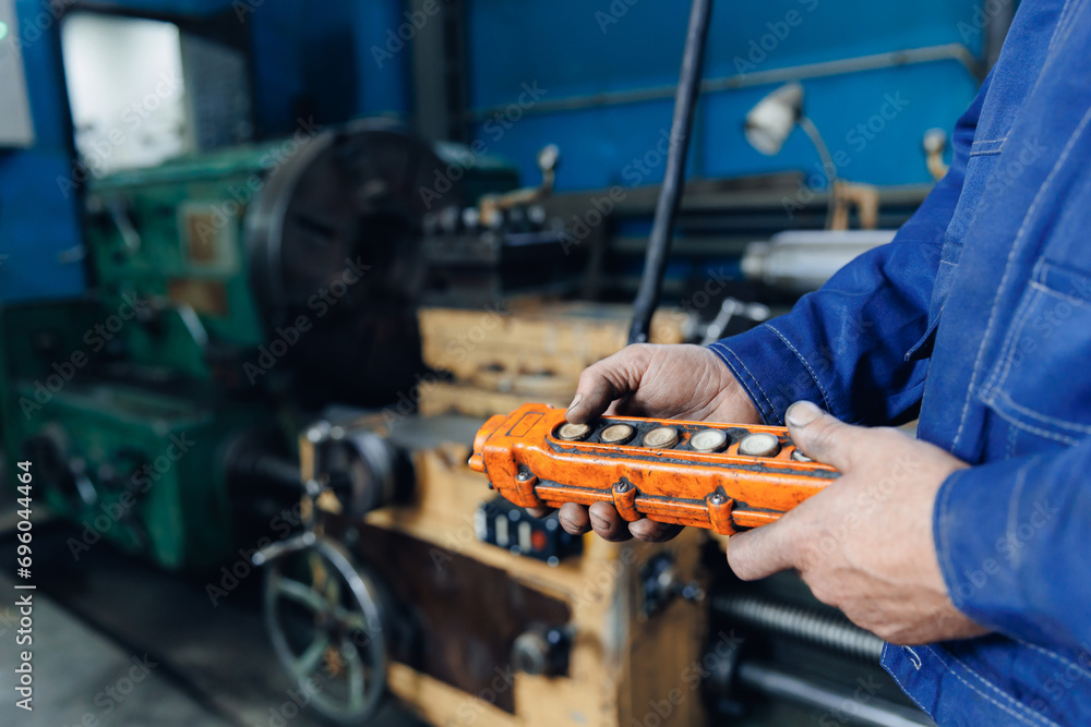 Concept factories for parts, fix workshops in garage. Mechanic worker use control remote milling machine for manufacturing detail of truck Concept factories for parts, fix workshops in garage. Mechanic worker use control remote milling machine for manufacturing detail of truck