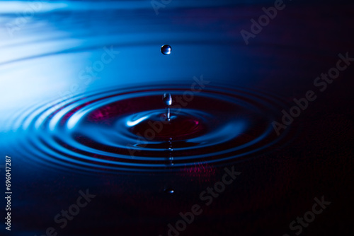 goccia d'acqua su acqua blu e fondale rosso photo