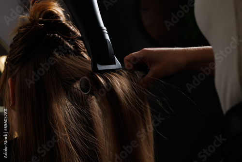 hairdresser blow-drying hair with a comb in a beauty salon, blow-drying hair close-up photo