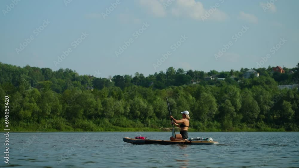 Young Adult Woman Practicing Standup Paddle Boarding In River In Summertime, Sport And Fitness Young Adult Woman Practicing Standup Paddle Boarding In River In Summertime, Sport And Fitness