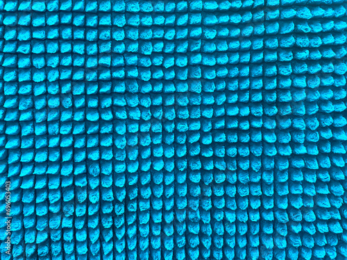 Background of light blue fabric close-up. Texture of blue microfiber background. Texture for design. Light blue floor mat surface texture.