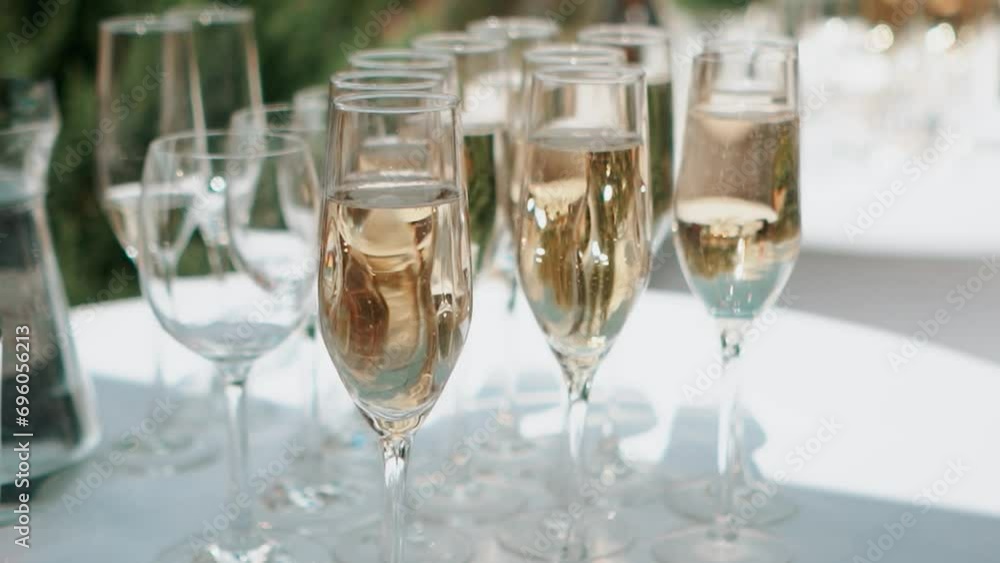 A glass of champagne stands on the festive table at the wedding of the bride and groom A glass of champagne stands on the festive table at the wedding of the bride and groom